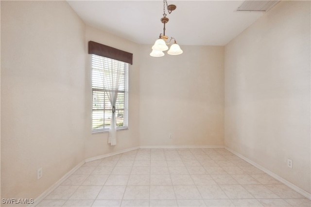 spare room featuring an inviting chandelier