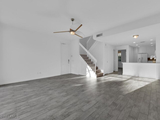 unfurnished living room with wood-type flooring and ceiling fan