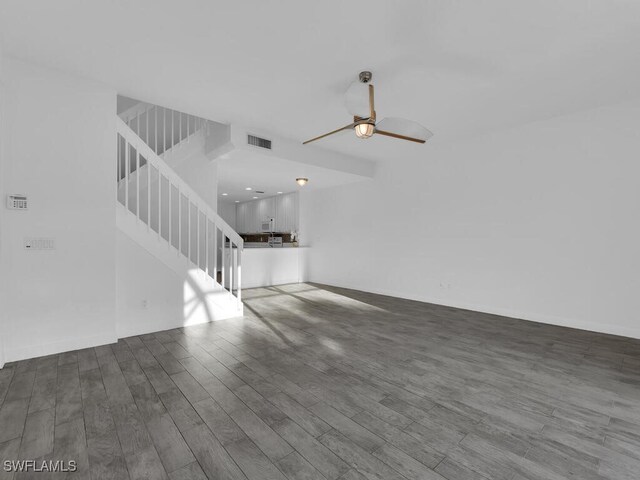 unfurnished living room featuring ceiling fan and dark hardwood / wood-style floors