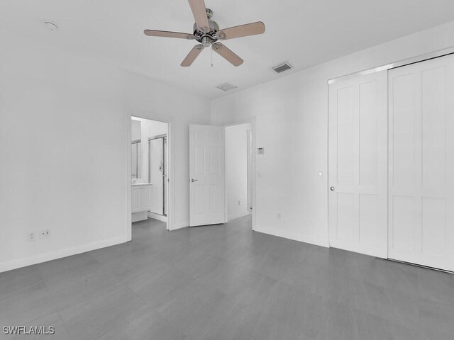 unfurnished bedroom with ceiling fan, a closet, and ensuite bathroom