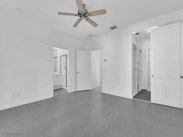 unfurnished bedroom featuring ceiling fan, connected bathroom, and a walk in closet