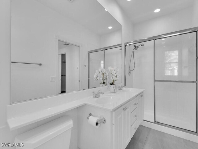 bathroom featuring tile patterned floors, a shower with shower door, vanity, and toilet