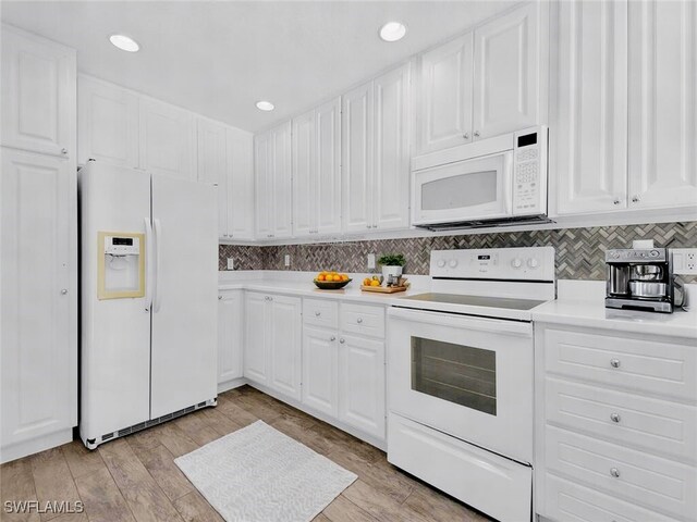 kitchen featuring tasteful backsplash, white appliances, light hardwood / wood-style floors, and white cabinets