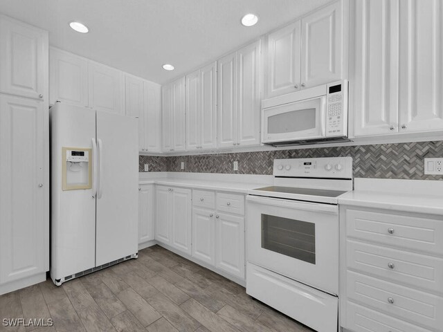 kitchen featuring white appliances, light hardwood / wood-style floors, white cabinets, and backsplash