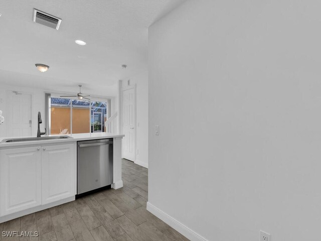 kitchen with light hardwood / wood-style flooring, sink, white cabinets, and dishwasher