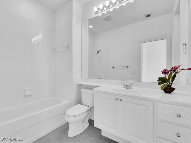 full bathroom featuring vanity, tiled shower / bath combo, toilet, and tile patterned flooring