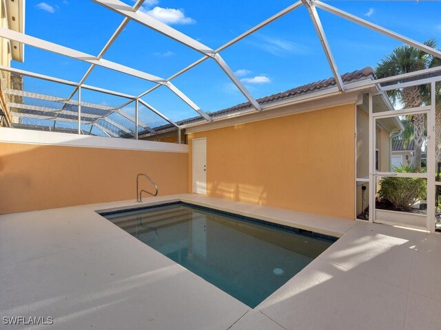 view of swimming pool with glass enclosure and a patio area