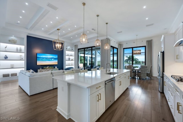 kitchen featuring stainless steel appliances, sink, a center island with sink, and white cabinets