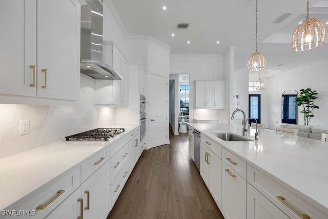 kitchen featuring wall chimney range hood, hanging light fixtures, dark hardwood / wood-style flooring, stainless steel appliances, and sink