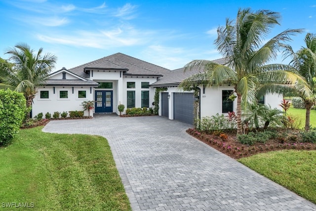 view of front of house with a front yard, french doors, and a garage