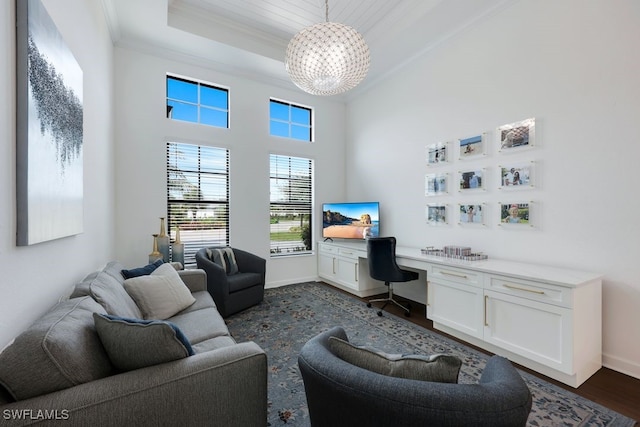 home office featuring built in desk, a tray ceiling, dark hardwood / wood-style floors, a high ceiling, and crown molding