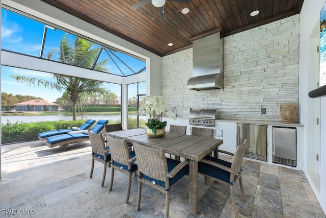 view of patio with exterior kitchen, ceiling fan, grilling area, a lanai, and a water view