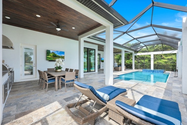 view of swimming pool featuring a patio area, glass enclosure, and ceiling fan