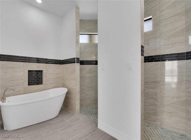 bathroom featuring independent shower and bath and tile walls