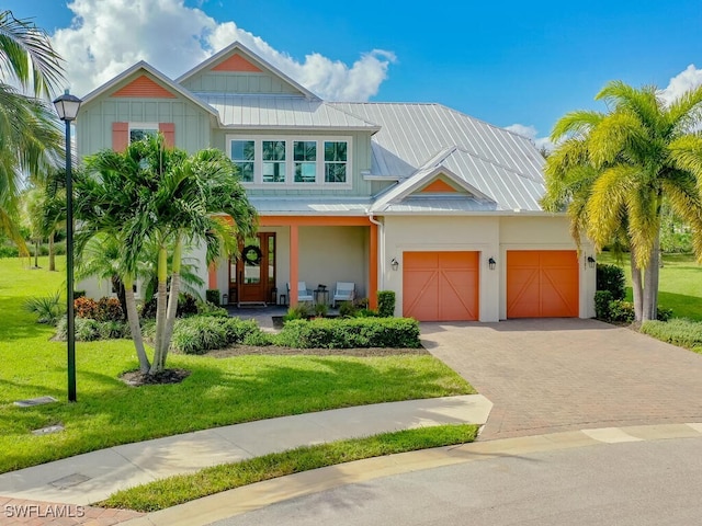 view of front of property with a front lawn, covered porch, and a garage