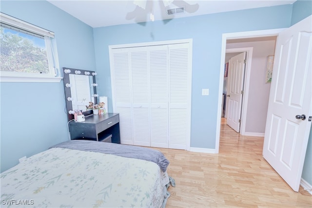 bedroom featuring a closet, light hardwood / wood-style floors, and ceiling fan