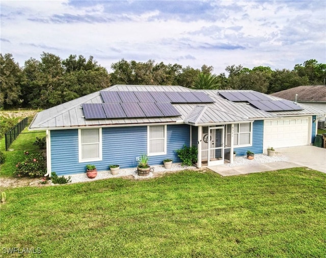 view of front of house with solar panels, a garage, and a front lawn