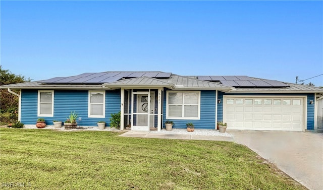 view of front of property with a front yard, solar panels, and a garage