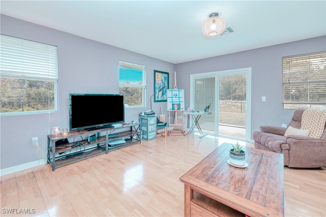 living room with light hardwood / wood-style floors and a healthy amount of sunlight