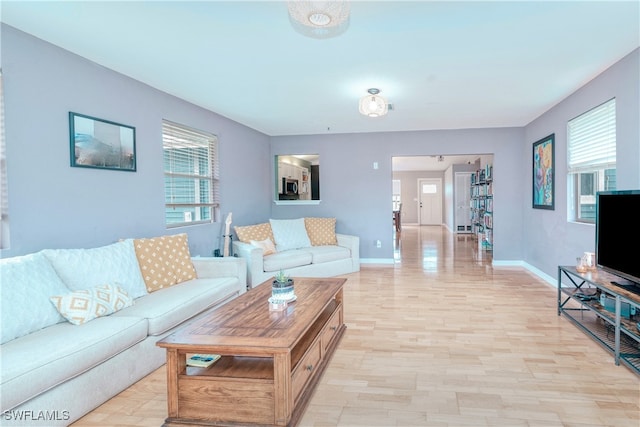 living room featuring light wood-type flooring and a healthy amount of sunlight