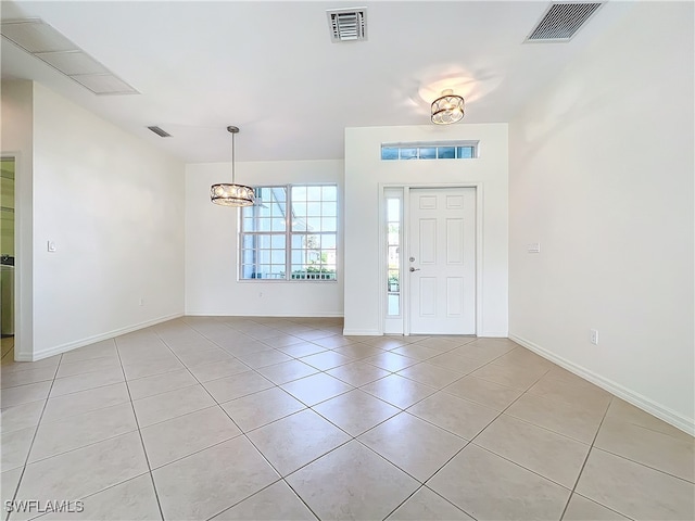 tiled entryway with an inviting chandelier