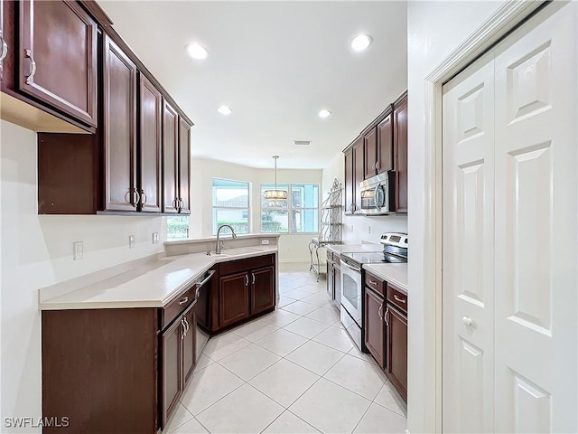 3452 Via Montana Way N, Fort Myers, FL 33917 - kitchen featuring a sink, light tile patterned floors, stainless steel appliances, light countertops, and a peninsula
