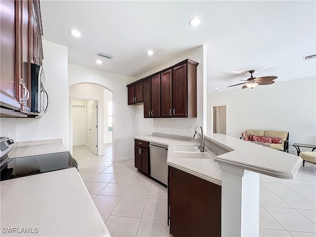 kitchen featuring kitchen peninsula, stainless steel appliances, sink, a breakfast bar, and ceiling fan