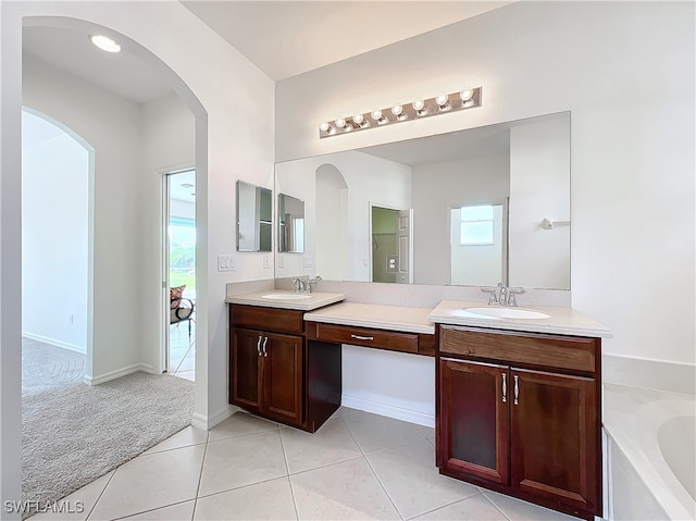 bathroom featuring vanity, a tub to relax in, and tile patterned floors