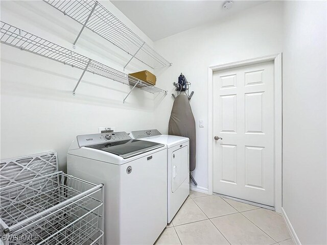3452 Via Montana Way N, Fort Myers, FL 33917 - washroom featuring separate washer and dryer, baseboards, laundry area, and light tile patterned floors