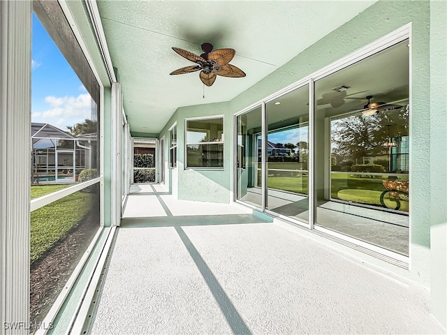 unfurnished sunroom featuring ceiling fan