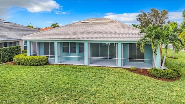 back of house featuring a sunroom and a lawn