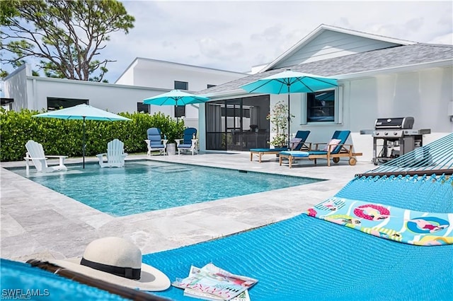 view of swimming pool with a patio area, a sunroom, and a grill