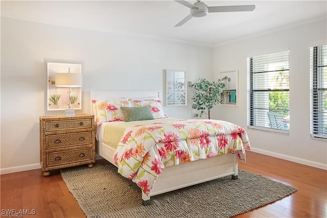 bedroom featuring ceiling fan, hardwood / wood-style floors, and crown molding