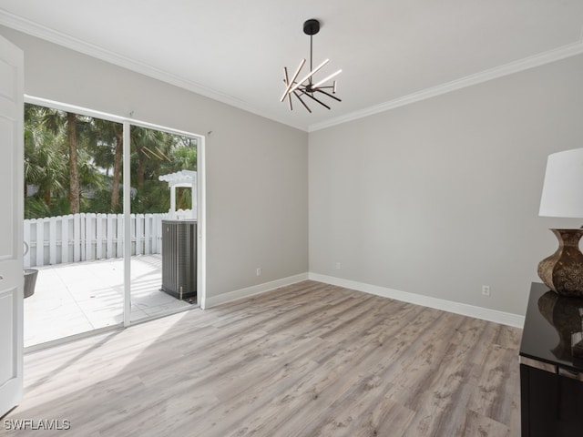 unfurnished dining area featuring light wood-type flooring, crown molding, and an inviting chandelier