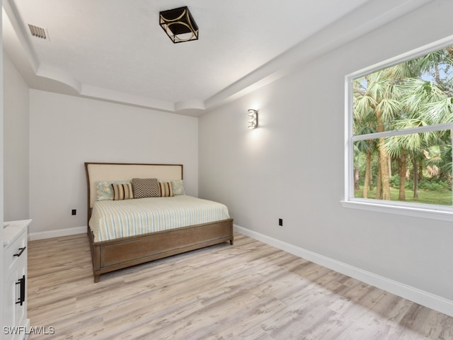 bedroom with light hardwood / wood-style flooring and multiple windows