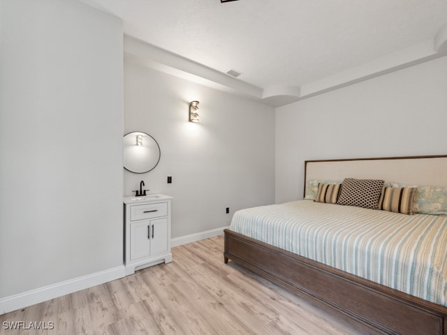 bedroom with light hardwood / wood-style floors and sink