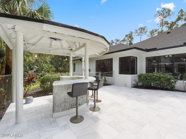 view of patio with ceiling fan, exterior bar, and a gazebo