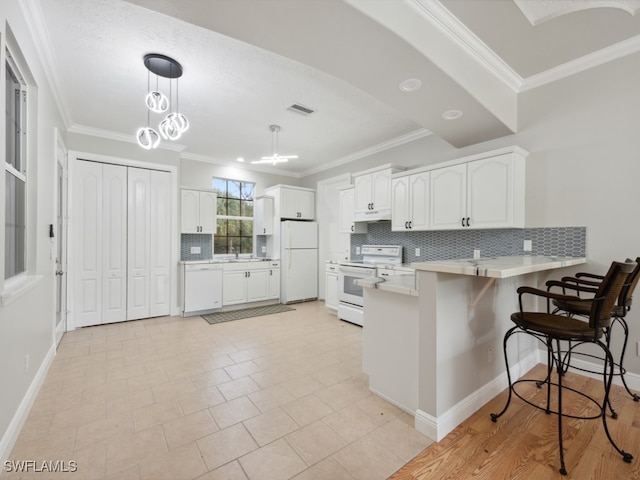 kitchen with white cabinets, kitchen peninsula, white appliances, backsplash, and a breakfast bar