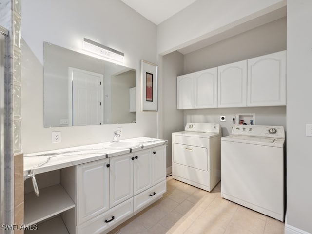 laundry room with light tile patterned floors, cabinets, sink, and washer and dryer