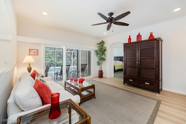 living room with ceiling fan and light hardwood / wood-style floors