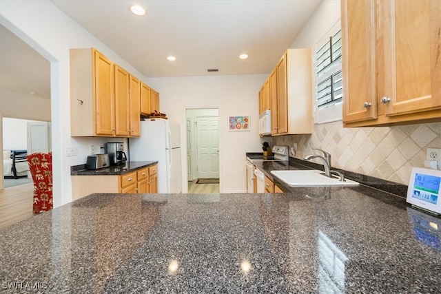 kitchen featuring sink, white appliances, tasteful backsplash, dark stone countertops, and light hardwood / wood-style floors