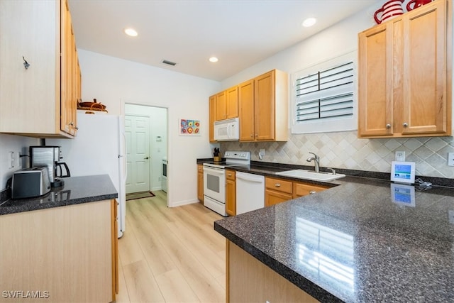 kitchen with decorative backsplash, white appliances, sink, kitchen peninsula, and light hardwood / wood-style flooring