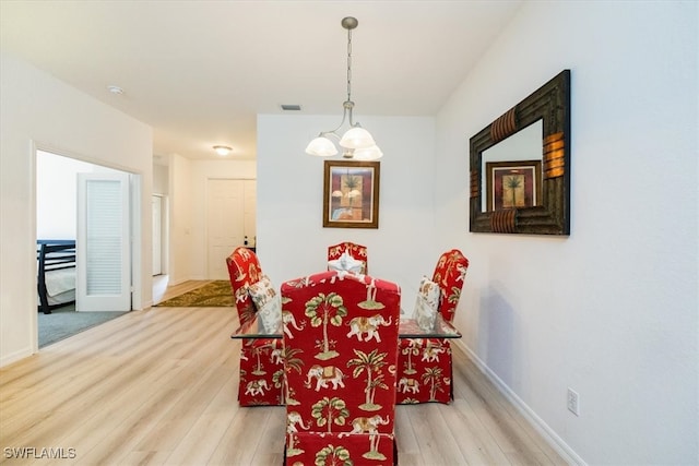 dining area featuring a chandelier and light hardwood / wood-style floors