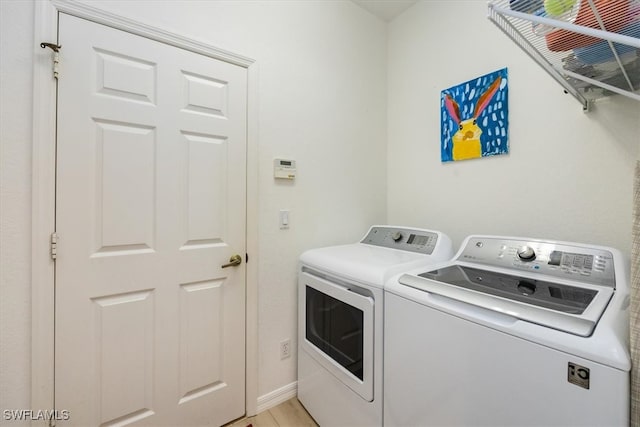 washroom featuring washing machine and dryer and light hardwood / wood-style flooring