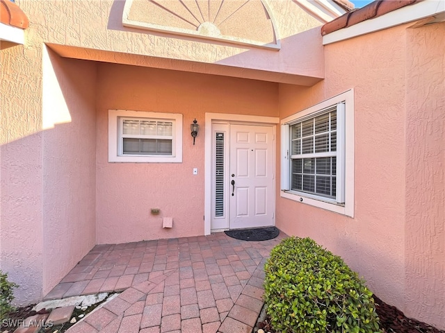 view of exterior entry with a patio area