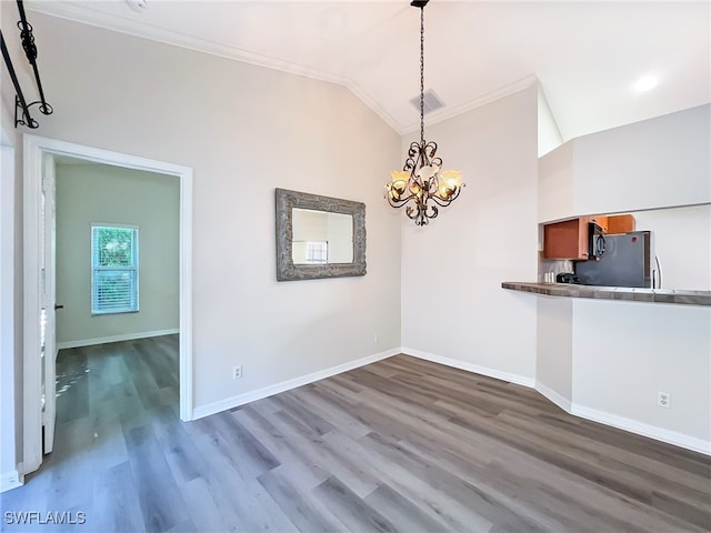 unfurnished dining area featuring a chandelier, crown molding, hardwood / wood-style floors, and lofted ceiling