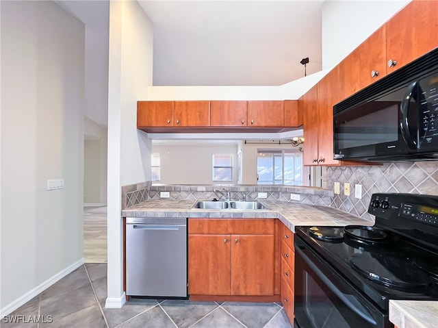 kitchen featuring sink, black appliances, and tile patterned flooring