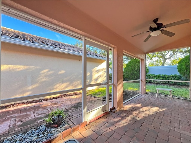 unfurnished sunroom with ceiling fan