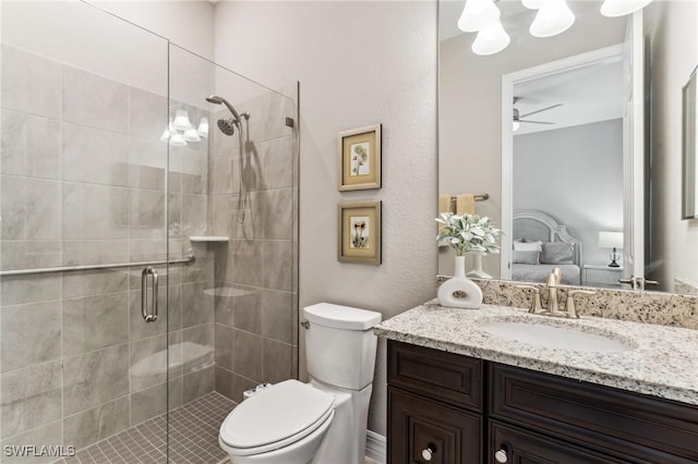 bathroom featuring ceiling fan, vanity, a shower with shower door, and toilet