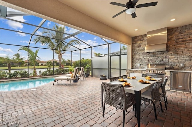 view of patio with ceiling fan, a grill, a lanai, and exterior kitchen